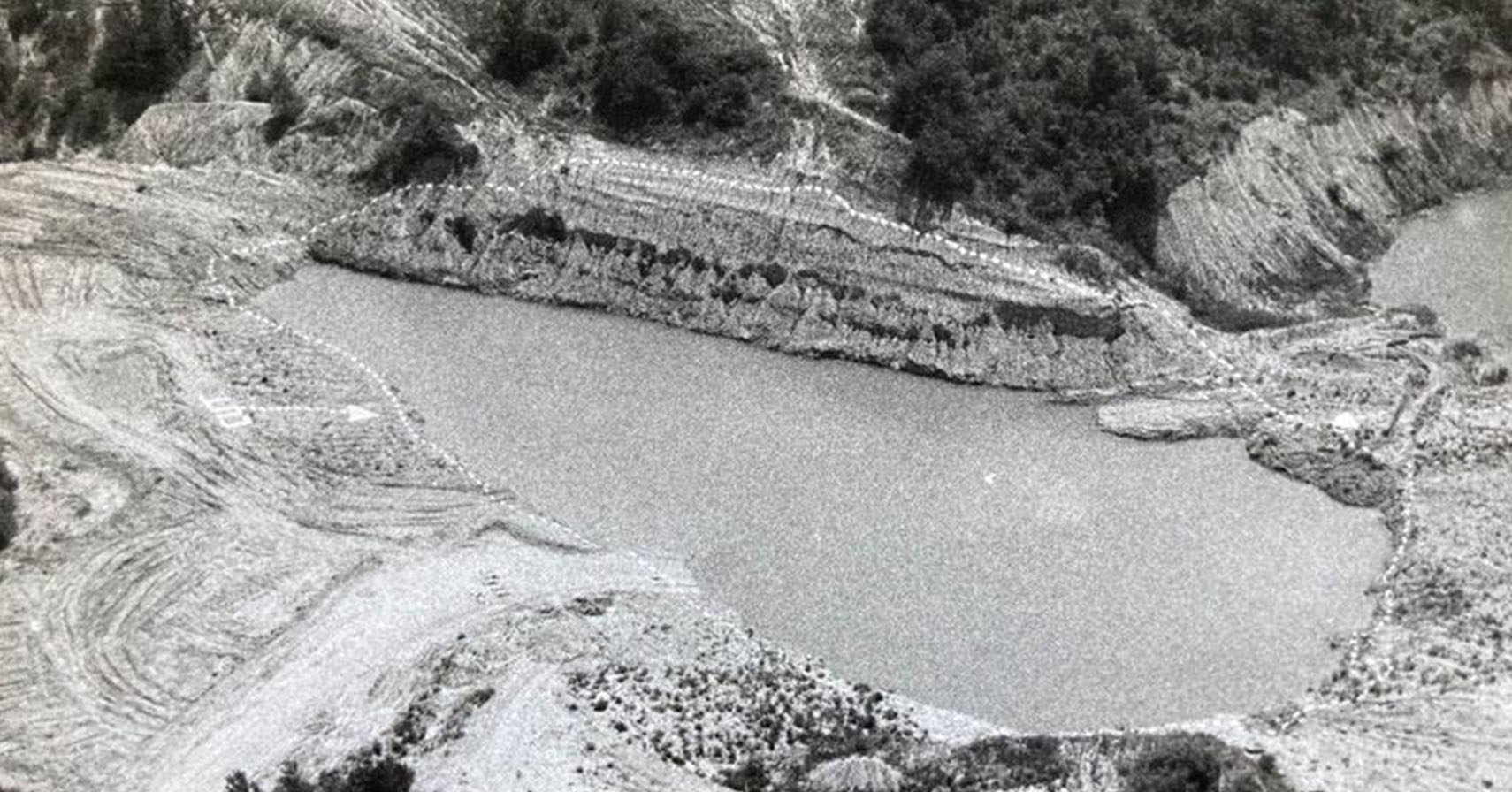 black and white photo of a quarry with a dotted white line surrounding it and an arrow pointing saying "cut"