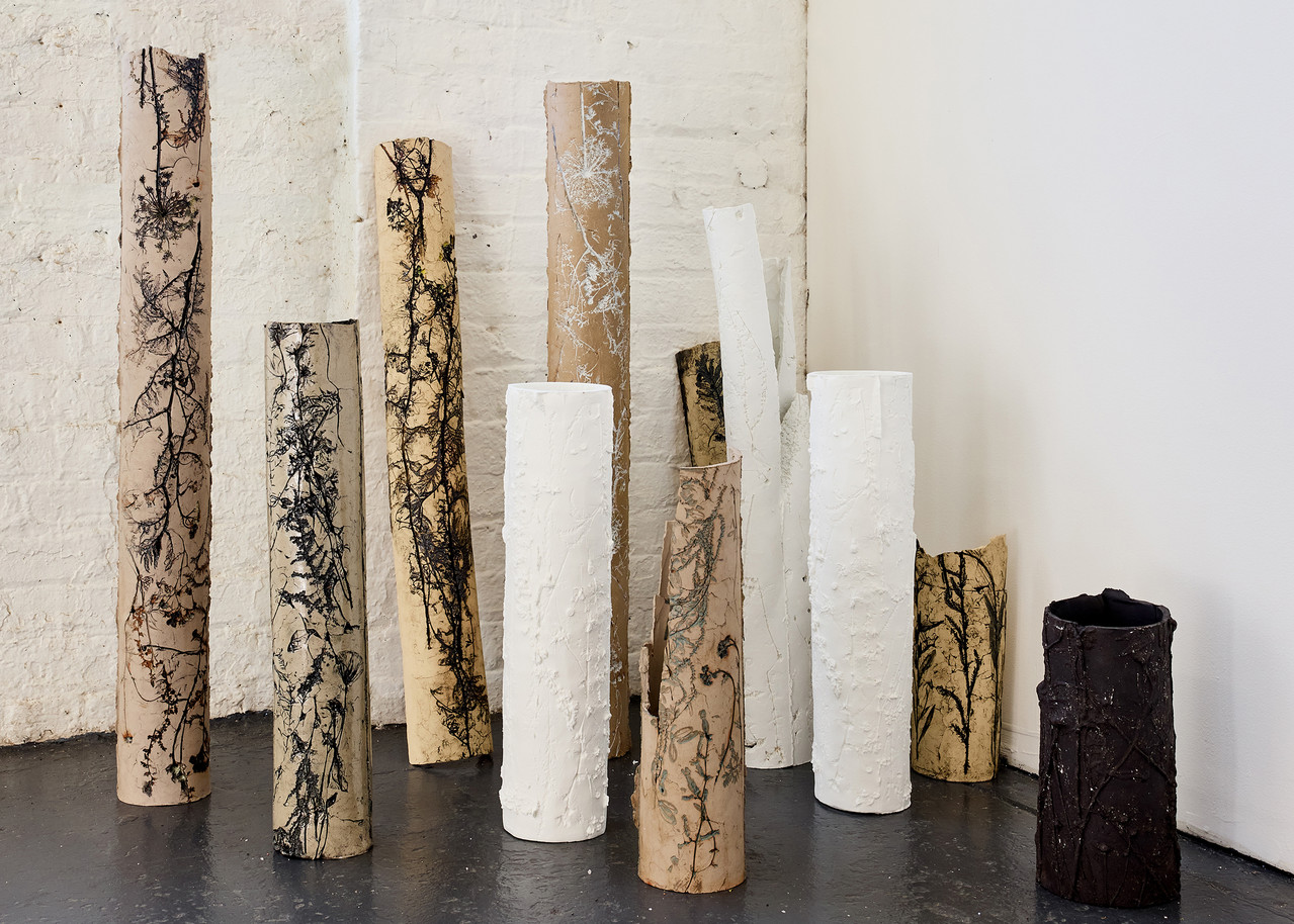 An image of several ceramic tubes with floral motifs