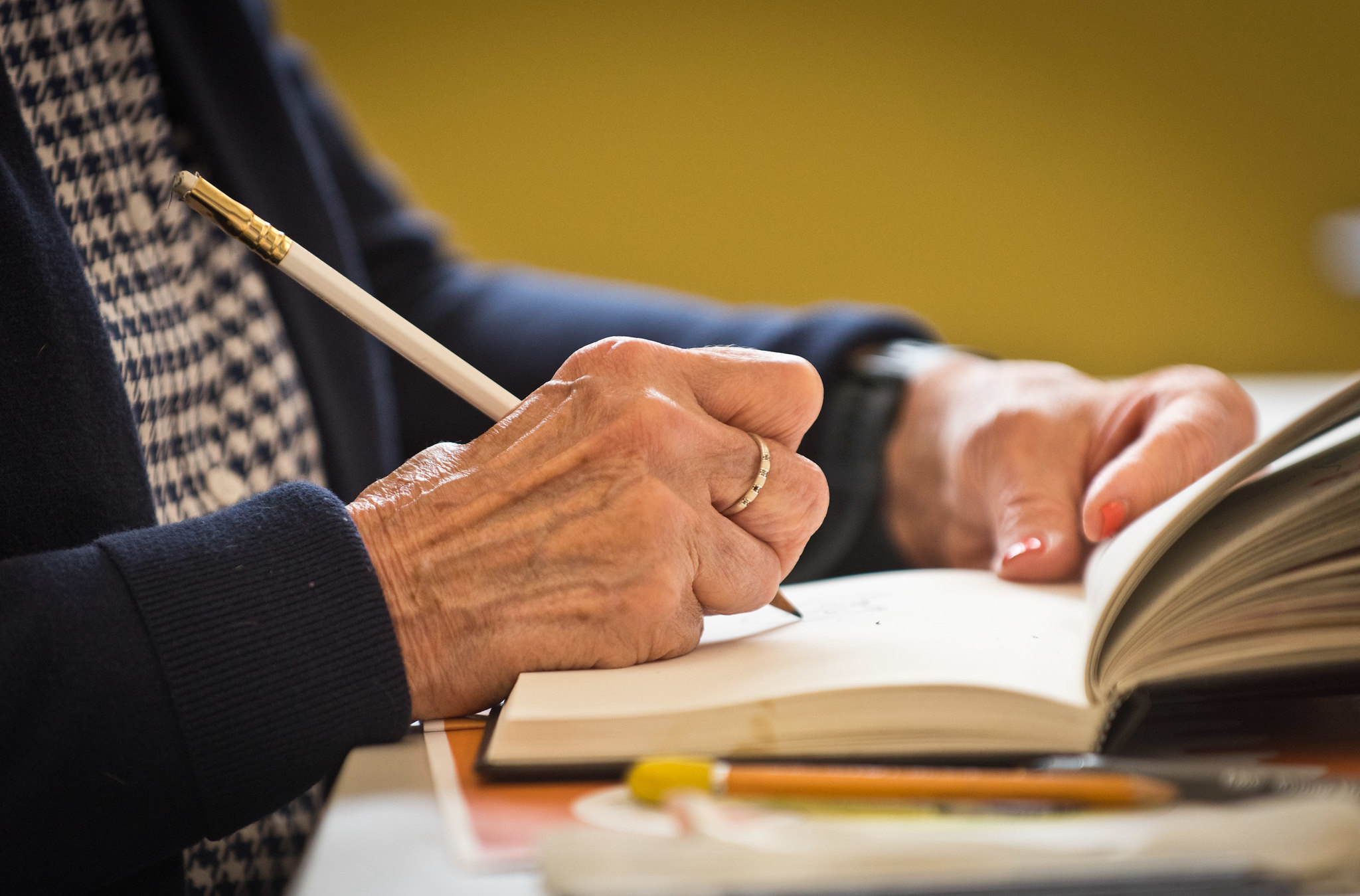 A photo of an older woman's hand writing in a journal